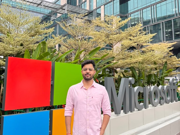 Nikhil Kumar standing beside a Microsoft sign